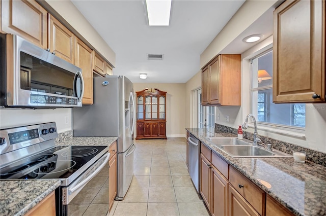 2961 Briar Cliff Dr, Palm Harbor, FL 34684 - kitchen featuring visible vents, a sink, light tile patterned floors, baseboards, and stainless steel appliances