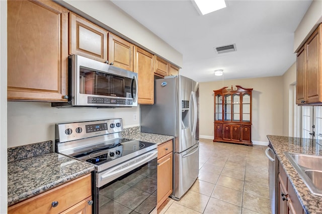2961 Briar Cliff Dr, Palm Harbor, FL 34684 - kitchen featuring visible vents, appliances with stainless steel finishes, light tile patterned floors, baseboards, and stone countertops