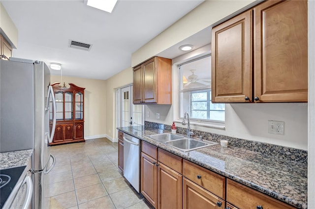 2961 Briar Cliff Dr, Palm Harbor, FL 34684 - kitchen featuring visible vents, appliances with stainless steel finishes, brown cabinets, a sink, and light tile patterned flooring