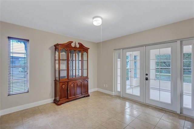 2961 Briar Cliff Dr, Palm Harbor, FL 34684 - entryway featuring light tile patterned floors, baseboards, and french doors