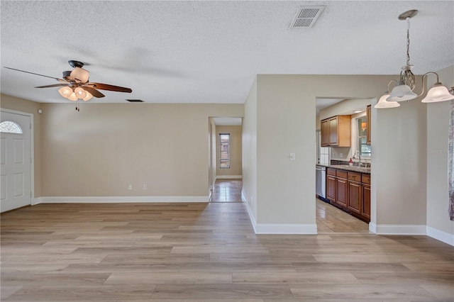 2961 Briar Cliff Dr, Palm Harbor, FL 34684 - foyer entrance featuring visible vents, a textured ceiling, ceiling fan with notable chandelier, and light wood-type flooring