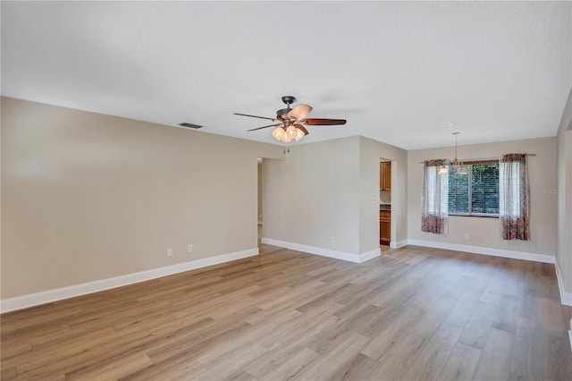2961 Briar Cliff Dr, Palm Harbor, FL 34684 - unfurnished room with light wood-style floors, baseboards, ceiling fan with notable chandelier, and visible vents