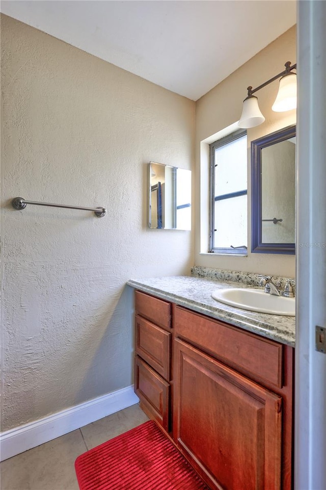 2961 Briar Cliff Dr, Palm Harbor, FL 34684 - bathroom featuring baseboards, a textured wall, vanity, and tile patterned flooring