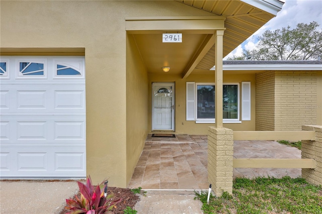 2961 Briar Cliff Dr, Palm Harbor, FL 34684 - doorway to property with brick siding, a garage, and stucco siding