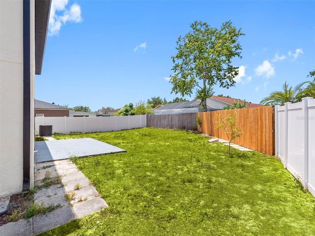 view of yard featuring a patio, a fenced backyard, and central AC