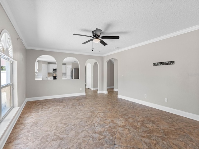 unfurnished living room with crown molding, arched walkways, ceiling fan, and a textured ceiling