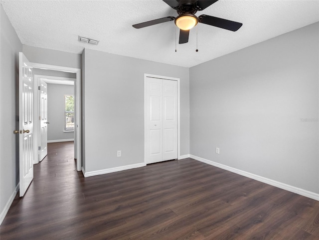 unfurnished bedroom featuring visible vents, baseboards, and dark wood-style floors