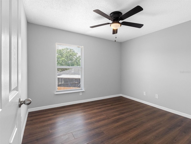 empty room featuring baseboards, a ceiling fan, dark wood-style flooring, and a textured ceiling