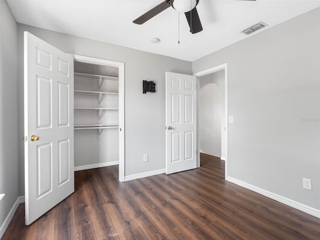 unfurnished bedroom with baseboards, a closet, wood finished floors, and visible vents
