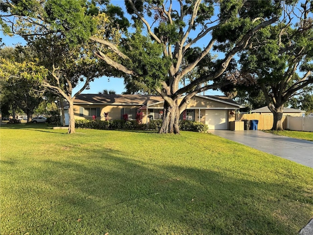 view of front of house featuring fence, driveway, a front lawn, and a garage