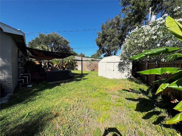 view of yard featuring an outdoor structure, a fenced backyard, and a shed