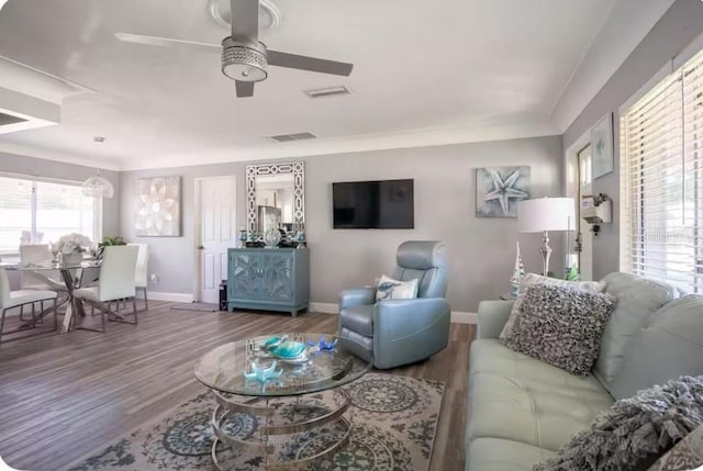 living area featuring baseboards, ceiling fan, wood finished floors, and visible vents