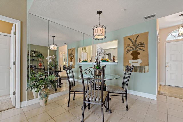 7 Island Park Pl Unit 204, Dunedin, FL 34698 - tiled dining room featuring baseboards and a textured ceiling