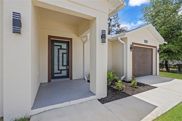 3803 E Curtis St, Tampa, FL 33610 - view of exterior entry with stucco siding, an attached garage, and concrete driveway