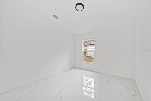 3803 E Curtis St, Tampa, FL 33610 - empty room featuring light marble finish floors, lofted ceiling, and baseboards