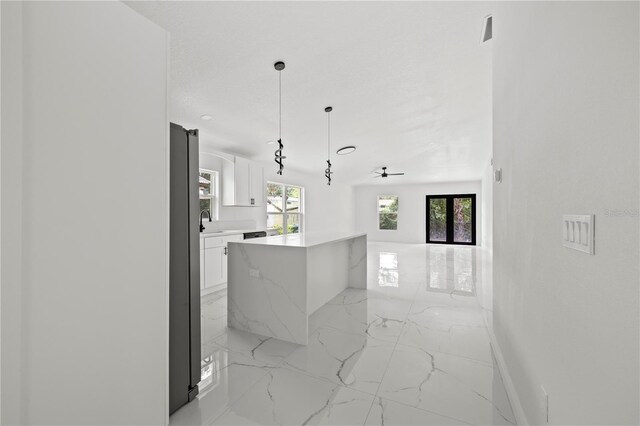 3803 E Curtis St, Tampa, FL 33610 - kitchen with light marble finish flooring, a sink, white cabinetry, open floor plan, and a kitchen island