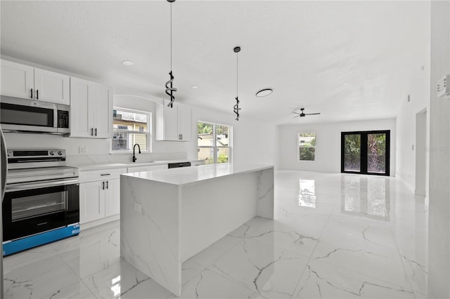 3803 E Curtis St, Tampa, FL 33610 - kitchen featuring stainless steel appliances, a sink, light marble finish floors, white cabinetry, and recessed lighting