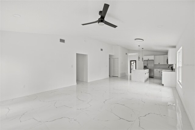 3803 E Curtis St, Tampa, FL 33610 - unfurnished living room featuring a ceiling fan, lofted ceiling, healthy amount of natural light, and light marble finish flooring