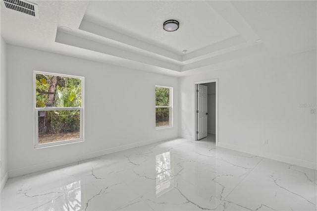 3803 E Curtis St, Tampa, FL 33610 - unfurnished room with a tray ceiling, baseboards, and marble finish flooring
