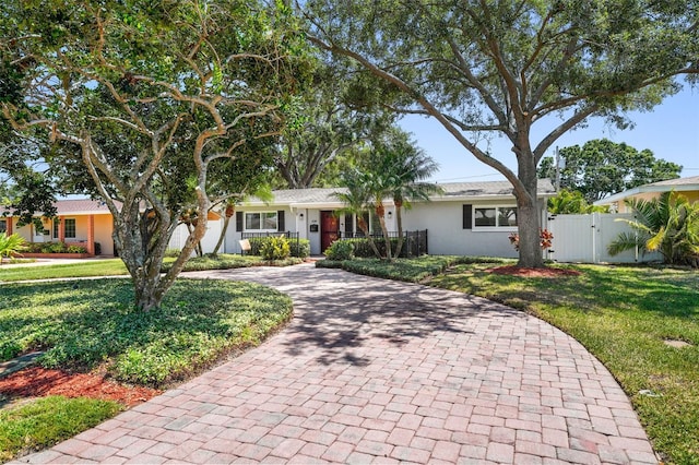 single story home featuring fence, curved driveway, a gate, and a front yard