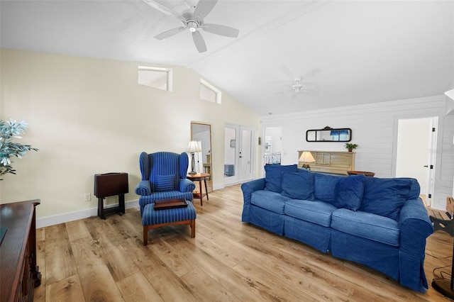 living area featuring baseboards, light wood finished floors, ceiling fan, and high vaulted ceiling