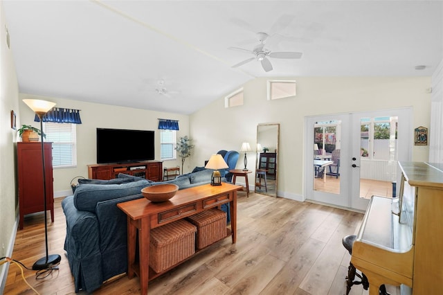 living area featuring lofted ceiling, baseboards, french doors, a ceiling fan, and light wood finished floors