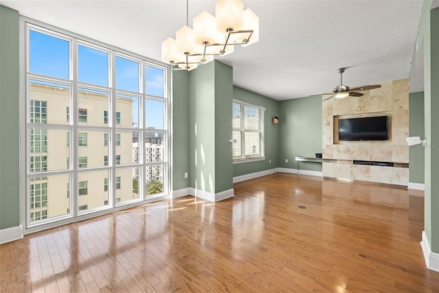 1227 E Madison St Unit 902, Tampa, FL 33602 - unfurnished living room featuring baseboards, wood finished floors, ceiling fan, and a premium fireplace