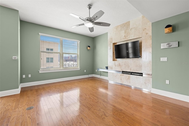 1227 E Madison St Unit 902, Tampa, FL 33602 - unfurnished living room with ceiling fan, light wood-style flooring, baseboards, and a fireplace