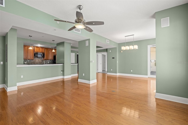 1227 E Madison St Unit 902, Tampa, FL 33602 - unfurnished living room featuring ceiling fan, light wood-style flooring, and baseboards