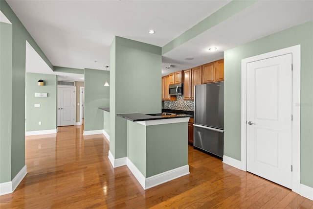 1227 E Madison St Unit 902, Tampa, FL 33602 - kitchen featuring stainless steel appliances, dark countertops, tasteful backsplash, a peninsula, and baseboards