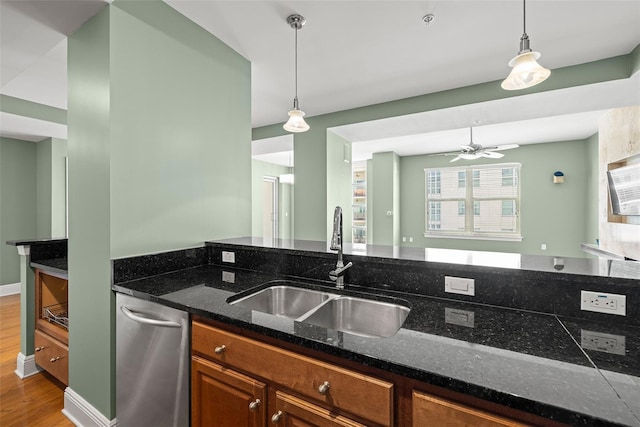 1227 E Madison St Unit 902, Tampa, FL 33602 - kitchen featuring a sink, brown cabinets, wood finished floors, dark stone counters, and decorative light fixtures