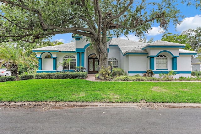 7314 Hunt Club Ln, Seminole, FL 33776 - mediterranean / spanish home featuring french doors, stucco siding, and a front yard
