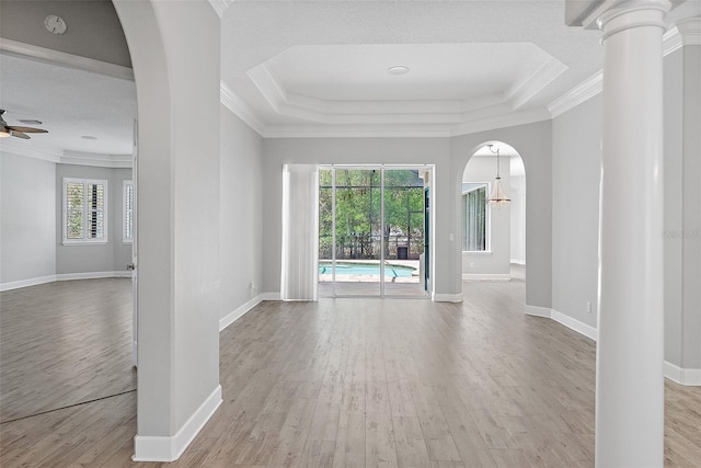 7314 Hunt Club Ln, Seminole, FL 33776 - unfurnished room featuring ornamental molding, wood finished floors, a raised ceiling, a ceiling fan, and arched walkways