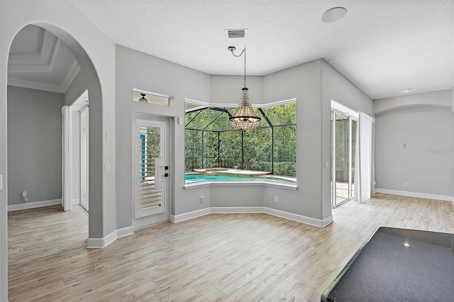 7314 Hunt Club Ln, Seminole, FL 33776 - unfurnished dining area with wood finished floors, plenty of natural light, arched walkways, and baseboards