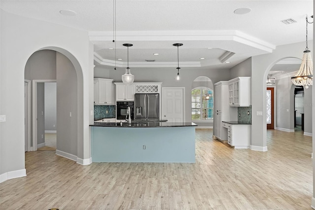 7314 Hunt Club Ln, Seminole, FL 33776 - kitchen with stainless steel fridge with ice dispenser, arched walkways, dark countertops, black oven, and crown molding