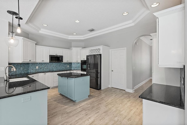 7314 Hunt Club Ln, Seminole, FL 33776 - kitchen featuring black appliances, a sink, a raised ceiling, arched walkways, and tasteful backsplash
