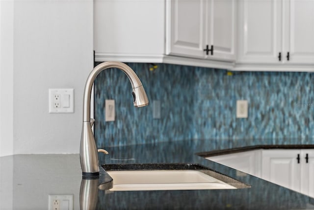 7314 Hunt Club Ln, Seminole, FL 33776 - kitchen view of dark countertops, a sink, white cabinetry, and tasteful backsplash