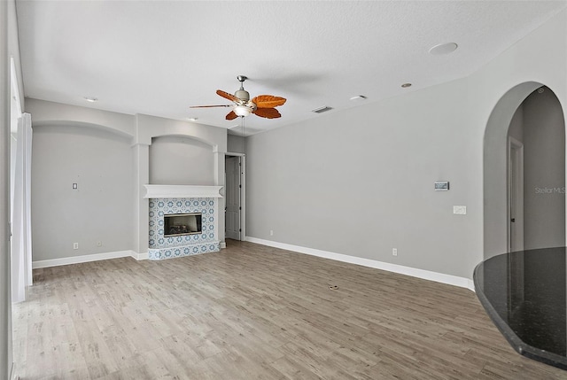 7314 Hunt Club Ln, Seminole, FL 33776 - unfurnished living room with ceiling fan, arched walkways, wood finished floors, and baseboards