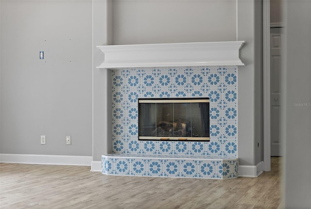 7314 Hunt Club Ln, Seminole, FL 33776 - detailed view of a tiled fireplace, wood finished floors, and baseboards