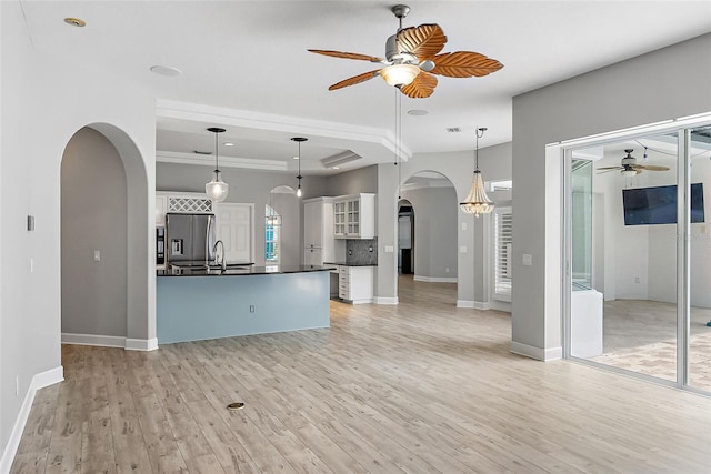 7314 Hunt Club Ln, Seminole, FL 33776 - unfurnished living room with arched walkways, ceiling fan, a sink, light wood finished floors, and baseboards