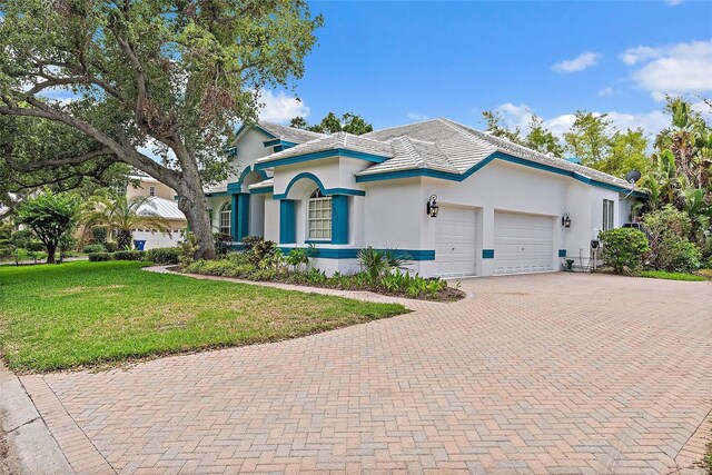 7314 Hunt Club Ln, Seminole, FL 33776 - view of front of house featuring stucco siding, decorative driveway, a garage, and a front yard
