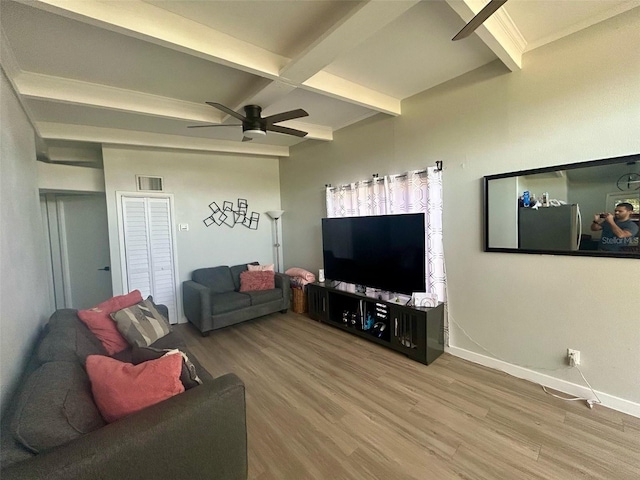 living room featuring beamed ceiling, ceiling fan, visible vents, and light wood finished floors
