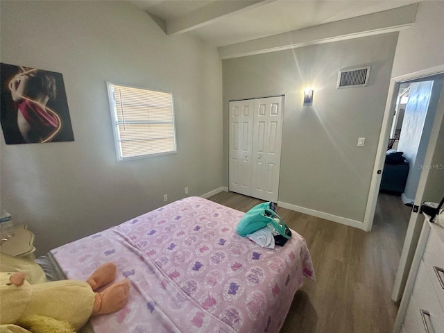 bedroom featuring visible vents, dark wood finished floors, beam ceiling, baseboards, and a closet