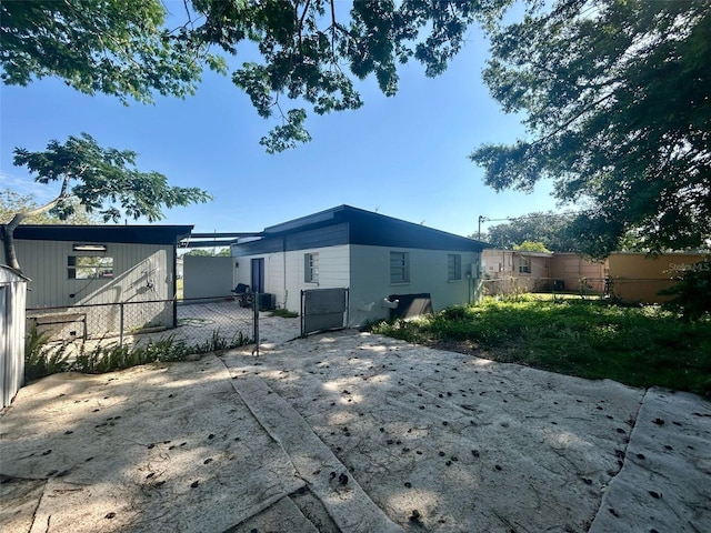 back of house featuring fence and central AC