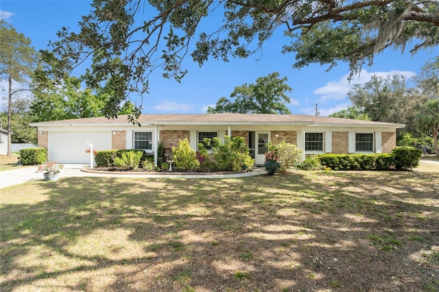 ranch-style home with brick siding, driveway, a garage, and a front yard