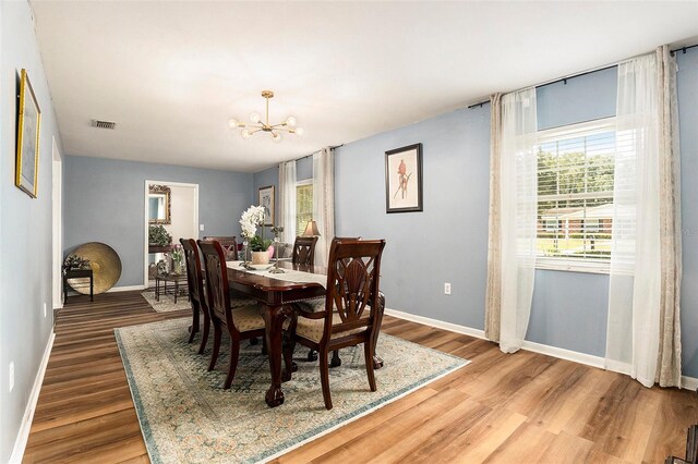 dining space with a chandelier, baseboards, and wood finished floors
