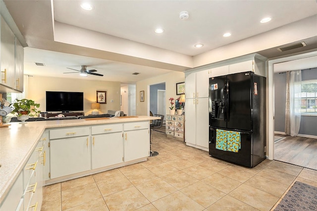 kitchen with black refrigerator with ice dispenser, a peninsula, light tile patterned floors, light countertops, and recessed lighting
