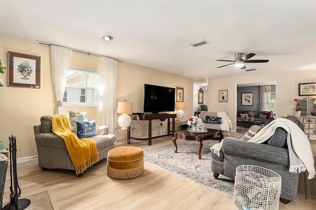 living area featuring plenty of natural light, light wood-type flooring, and ceiling fan