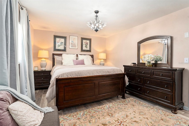 bedroom with a chandelier and light wood-style floors