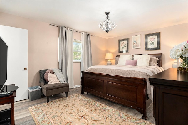 bedroom featuring a chandelier and light wood-style flooring